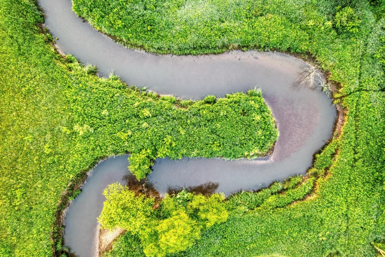 an aerial view of a river winding through a field