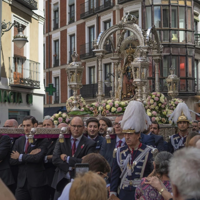 a very big procession on a street by some buildings