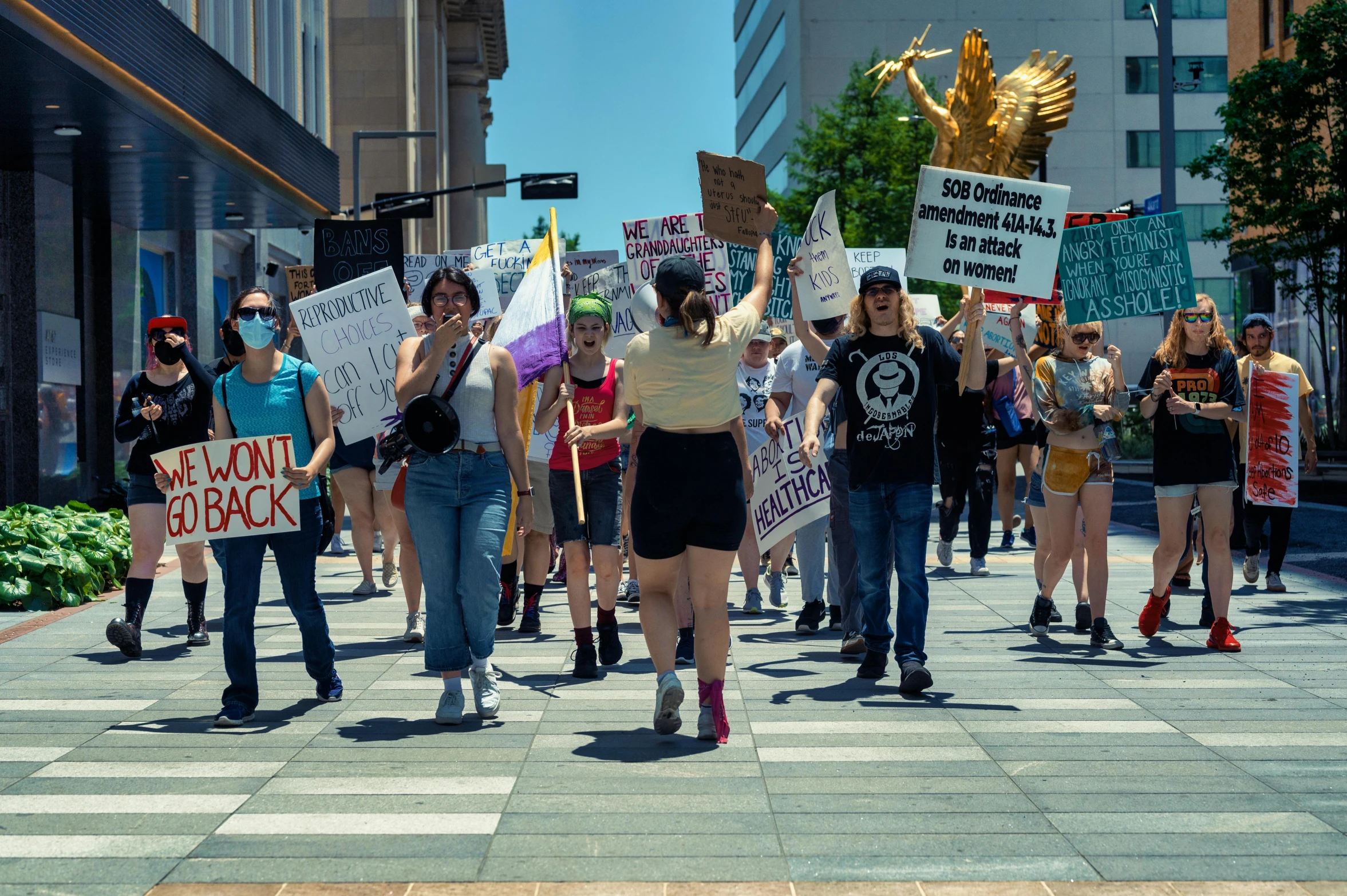 several people hold signs as they march down the street