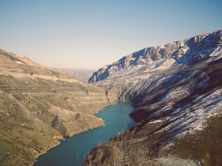 there is a man walking by the side of a mountain