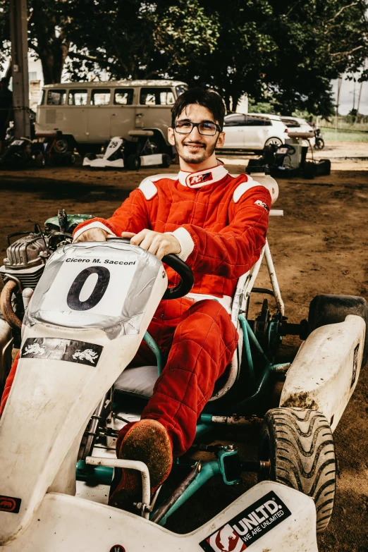 man in red suit sitting on dirt bike with number 0 on his back