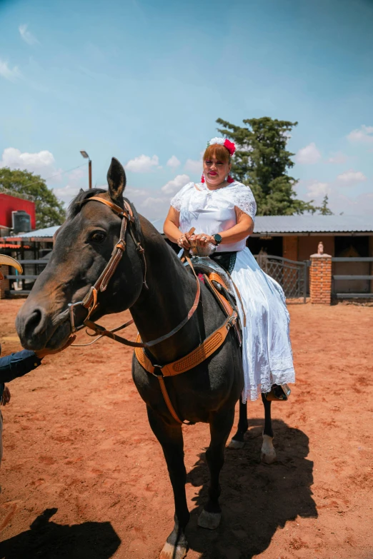 the woman is sitting on a horse outside