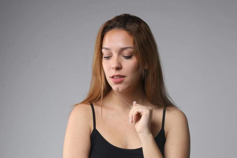 a girl that is touching her lip with a finger