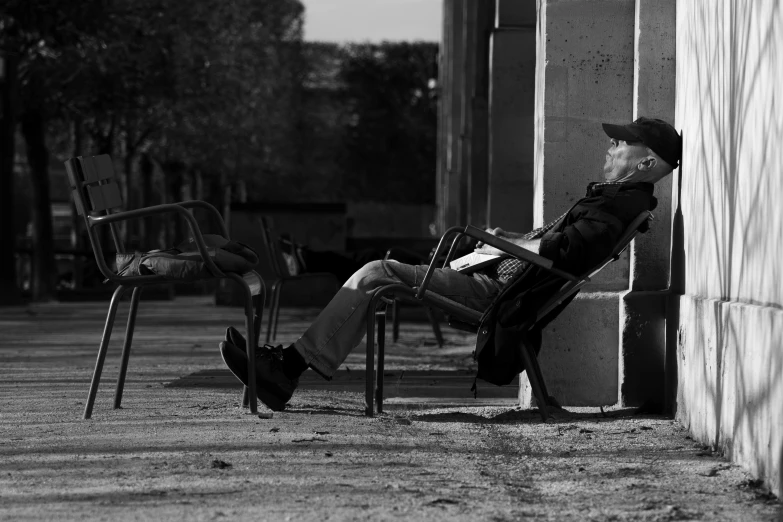 a man is sitting in a chair with a hat on