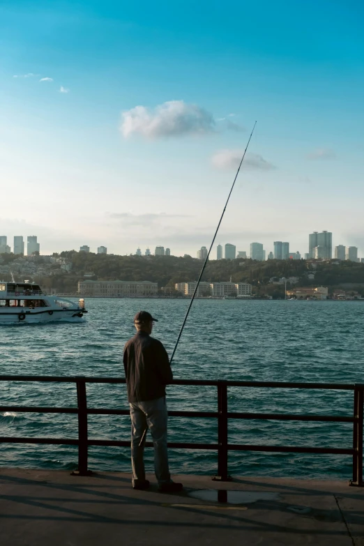 a man fishing from the pier near a body of water