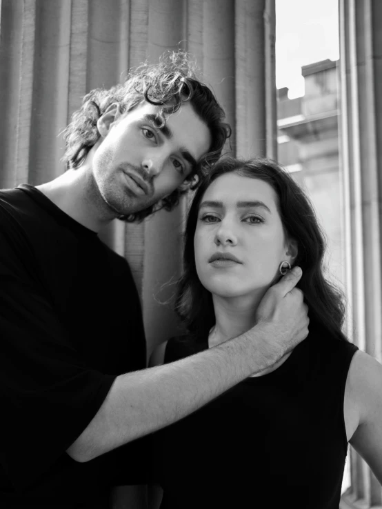 man holding woman's hair in front of window