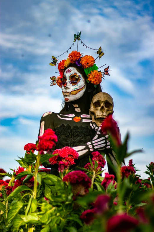 a skeleton statue with flower decorations is surrounded by flowers