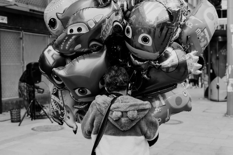 a person holding some balloons up to their head