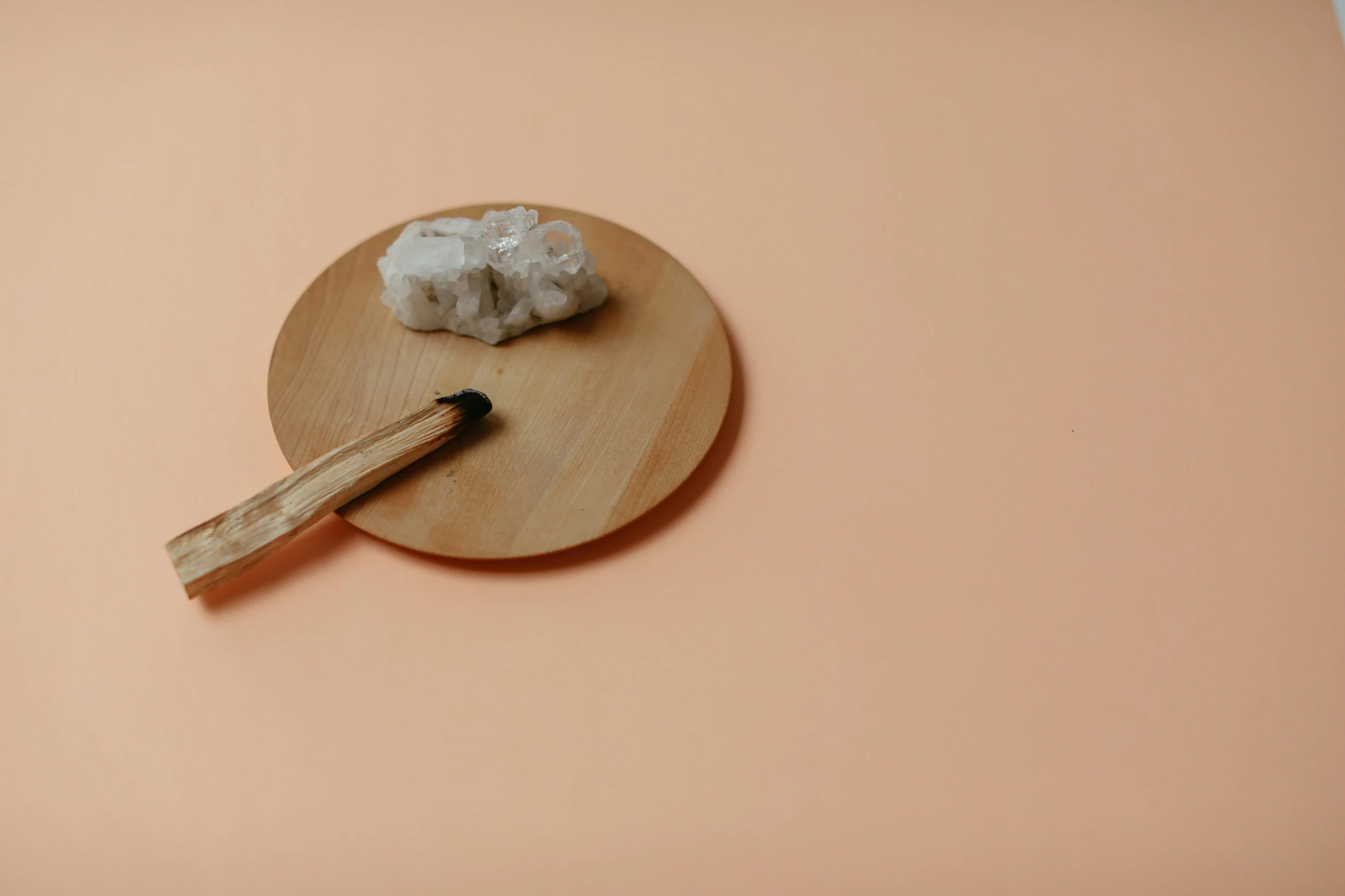 a wooden spoon with chopsticks that are resting on a plate