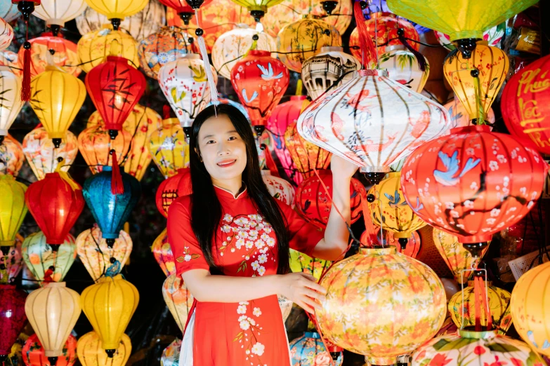 a woman holding onto an umbrella standing in front of some paper lanterns