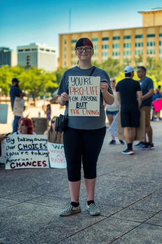 a woman stands in front of protesters with a sign that says house of imporative change