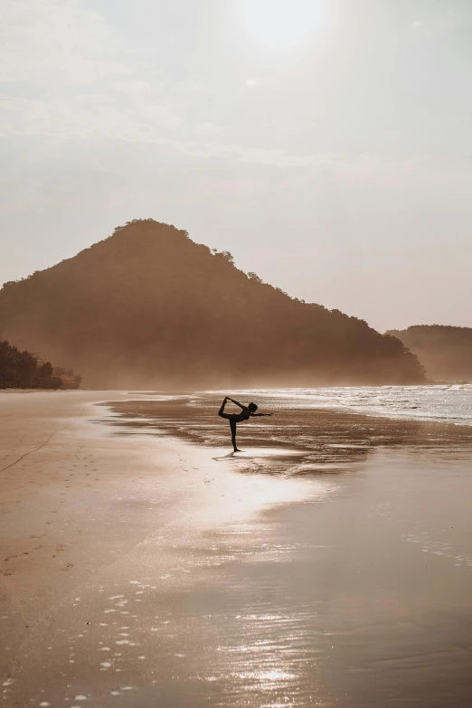 there is a person carrying a surfboard across the beach