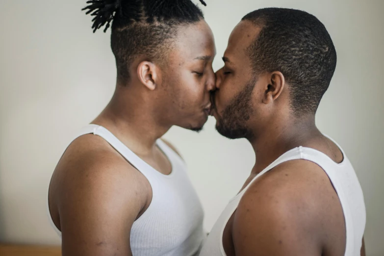 two black people kissing each other and one wearing white