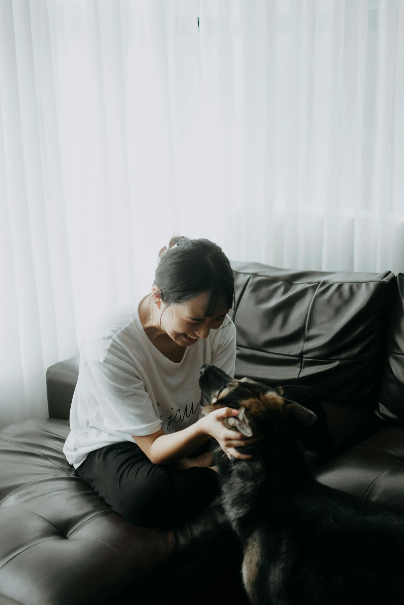 a woman sitting on top of a couch with her dog