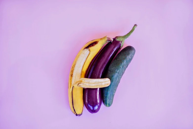 several bananas sitting next to each other on a purple background