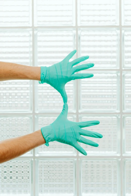 two hands in blue gloves holding each other