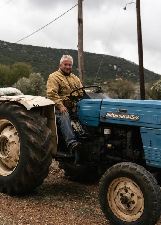 a man riding on the back of a large blue tractor