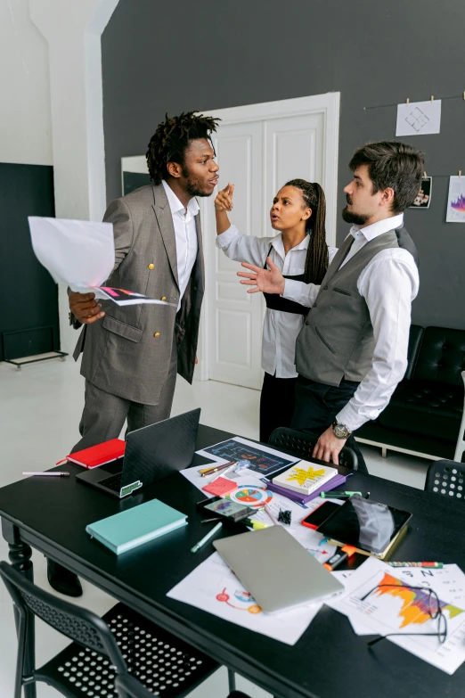 three people with papers around them having a discussion