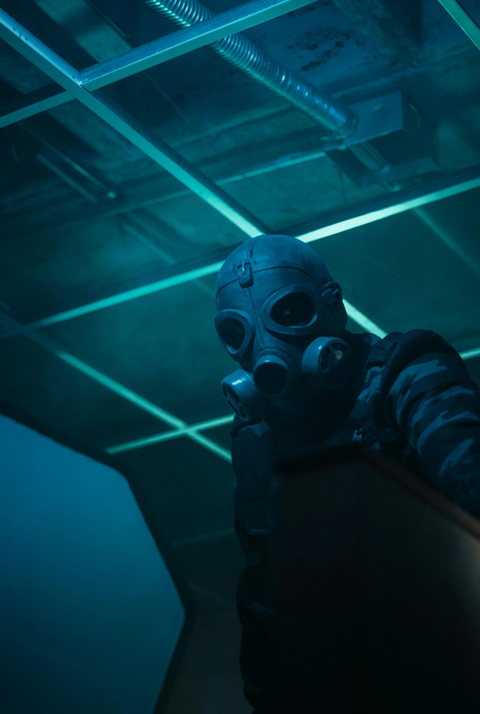 man wearing mask and holding gun in dark room