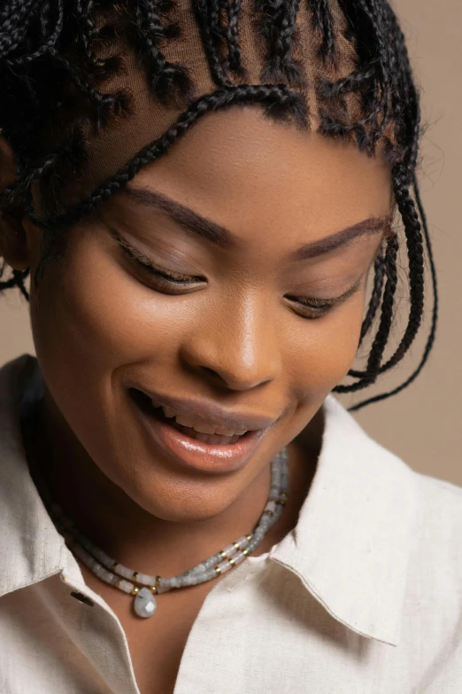 a woman smiles as she wears a silver chain