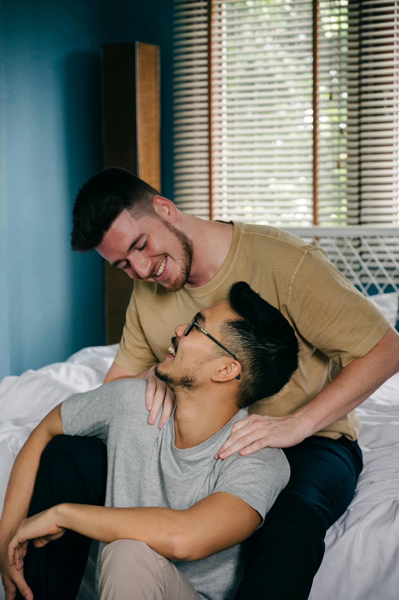 a man hugging another mans neck while they both look into each others eyes