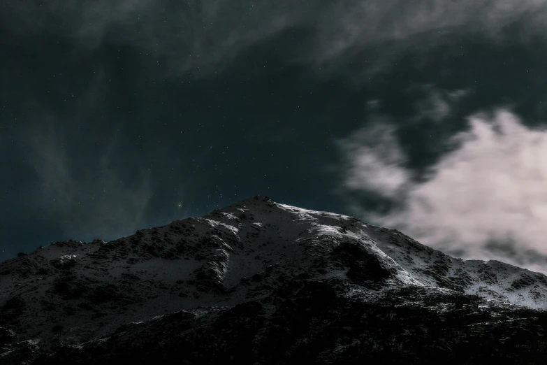 a dark and snowy mountain with some stars in the sky