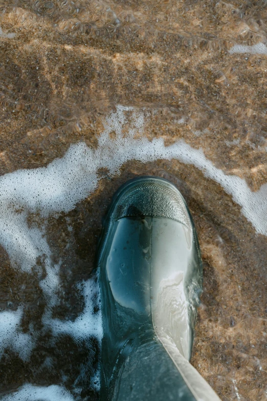 the feet of an ocean official walking along a beach