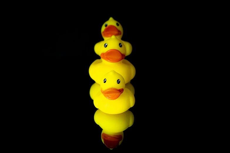 two ducks are floating in the water against a black background