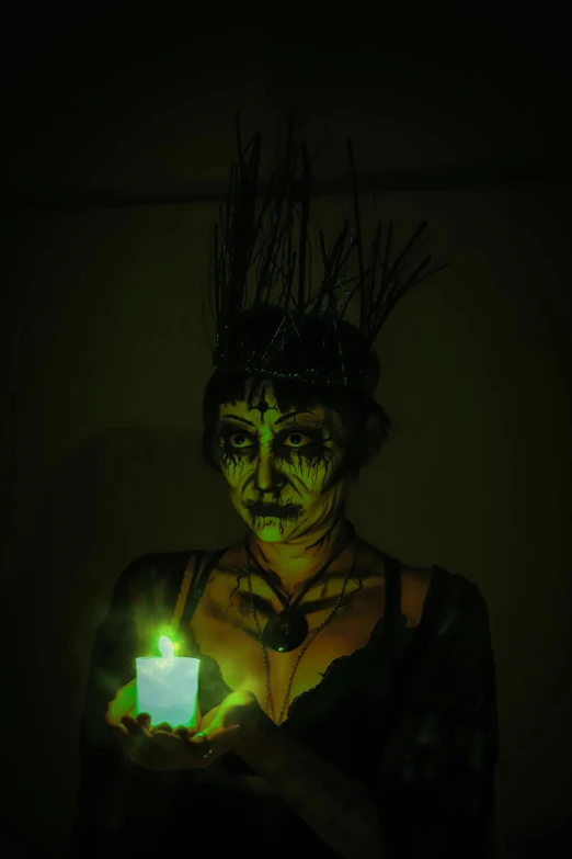 woman with makeup on holding a lite up tea light