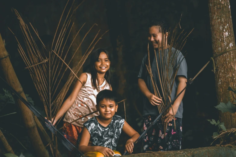 a family standing outside in front of trees smiling at the camera