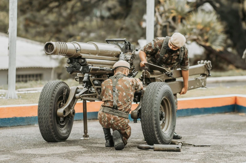 two soldiers setting up and working on a tank