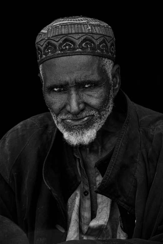 an old man wearing a black jacket and hat