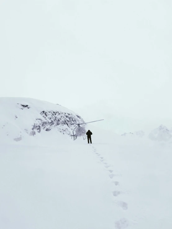 a man walking on snow covered ground with skis attached