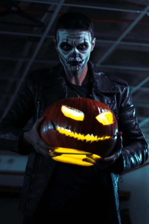 a person wearing a creepy mask holds a pumpkin