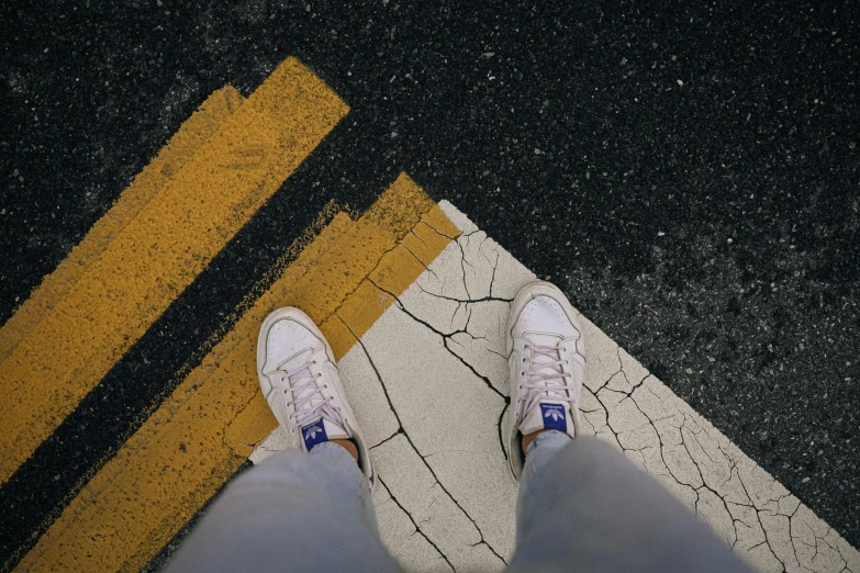 someone standing on a parking lane with white shoes