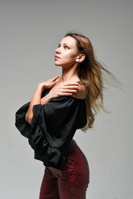 a woman with an unusual hair style posing in tight pants and boots