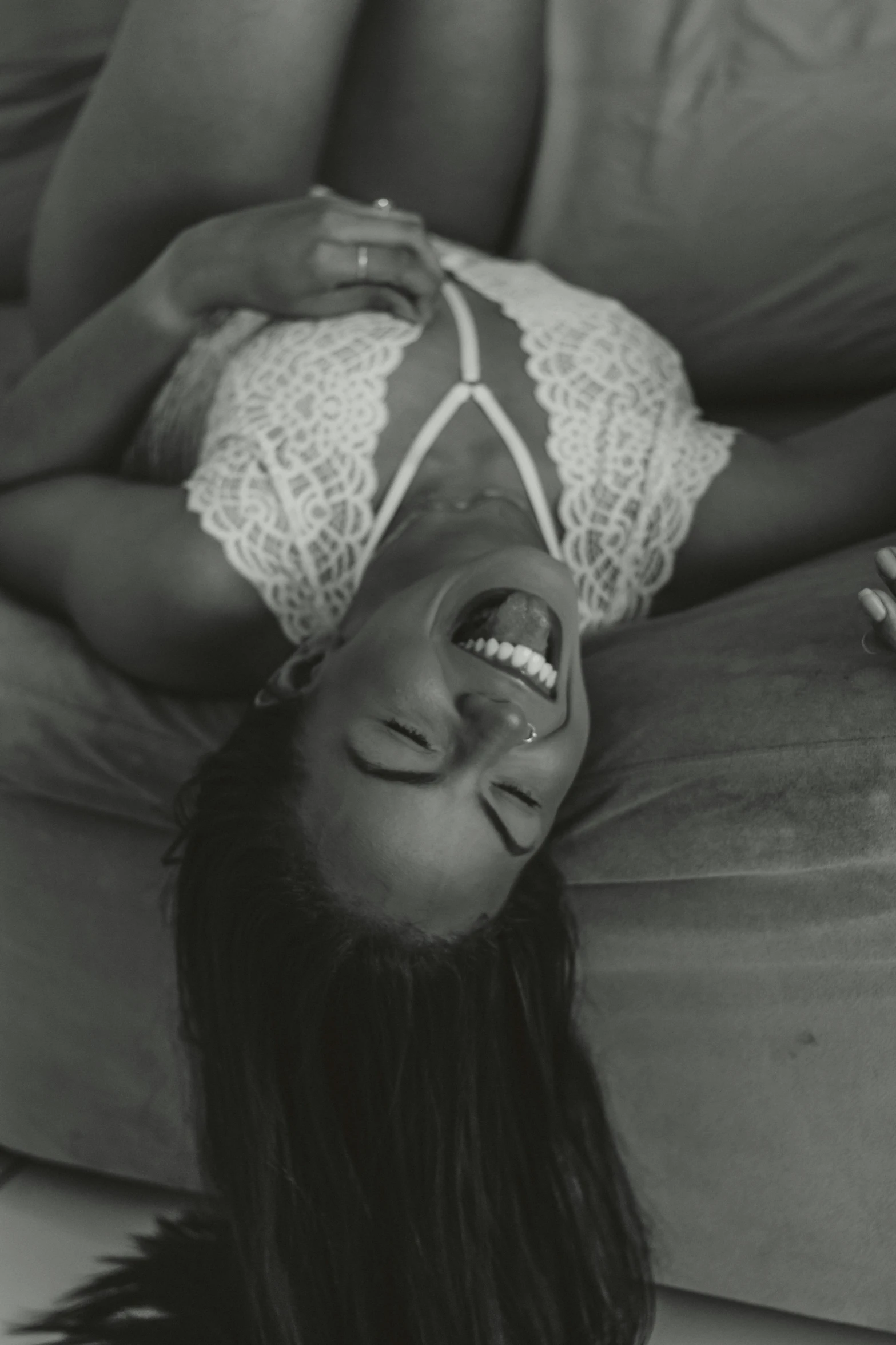 a woman is laying down and smiling with her hair in the air