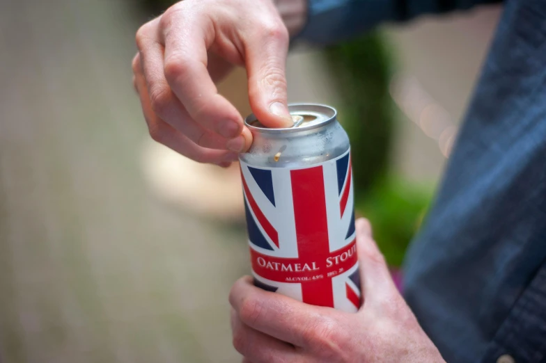 a person holding onto a can of drink