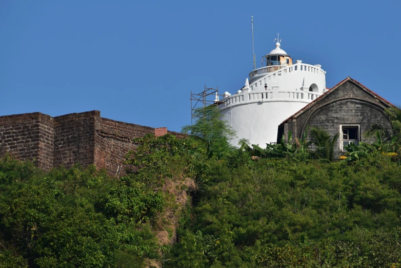 a building on top of a hill with trees surrounding