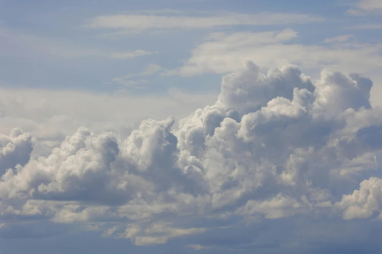 several clouds flying over the sky in the daytime