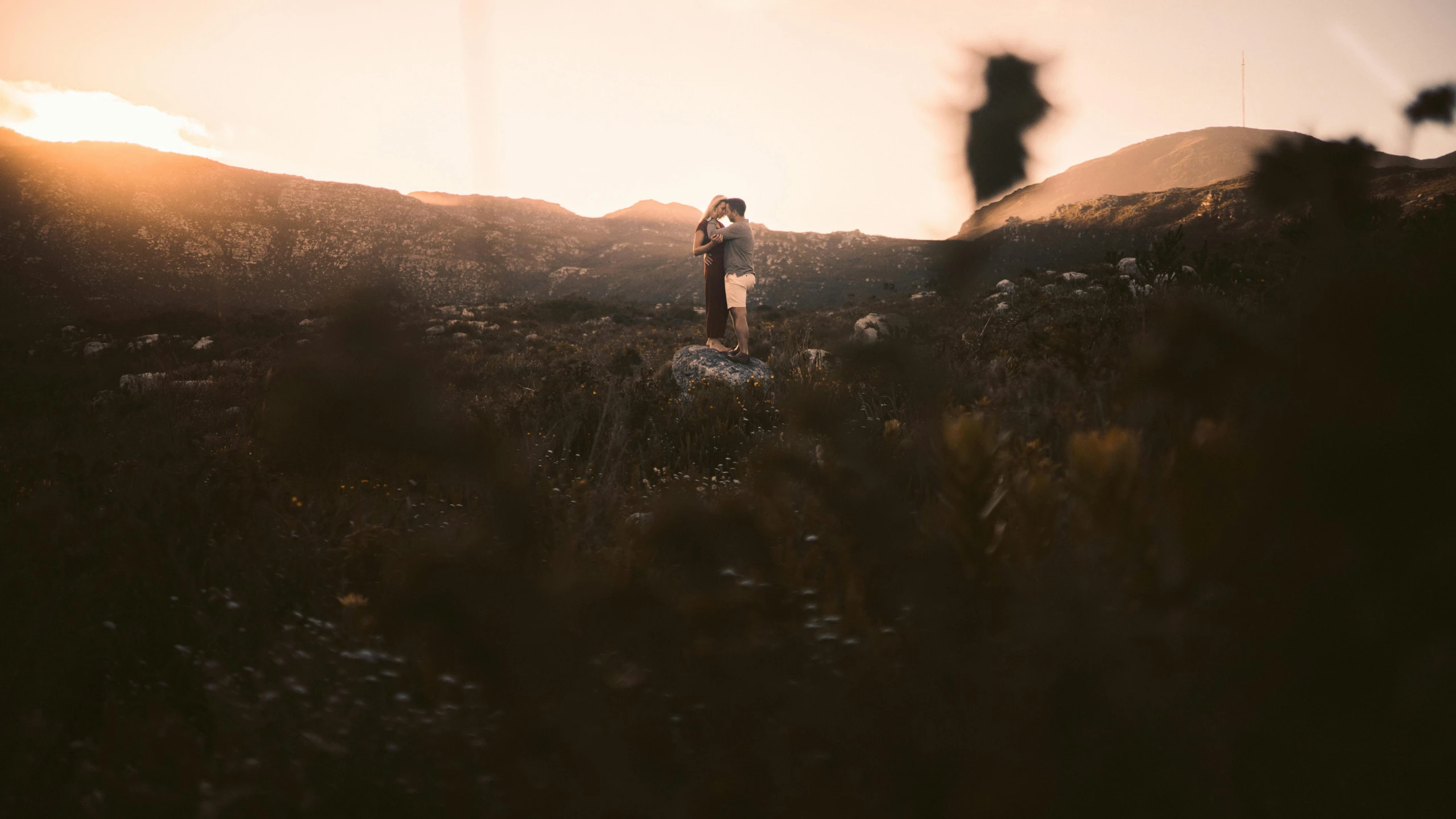 two people are in a field with mountains