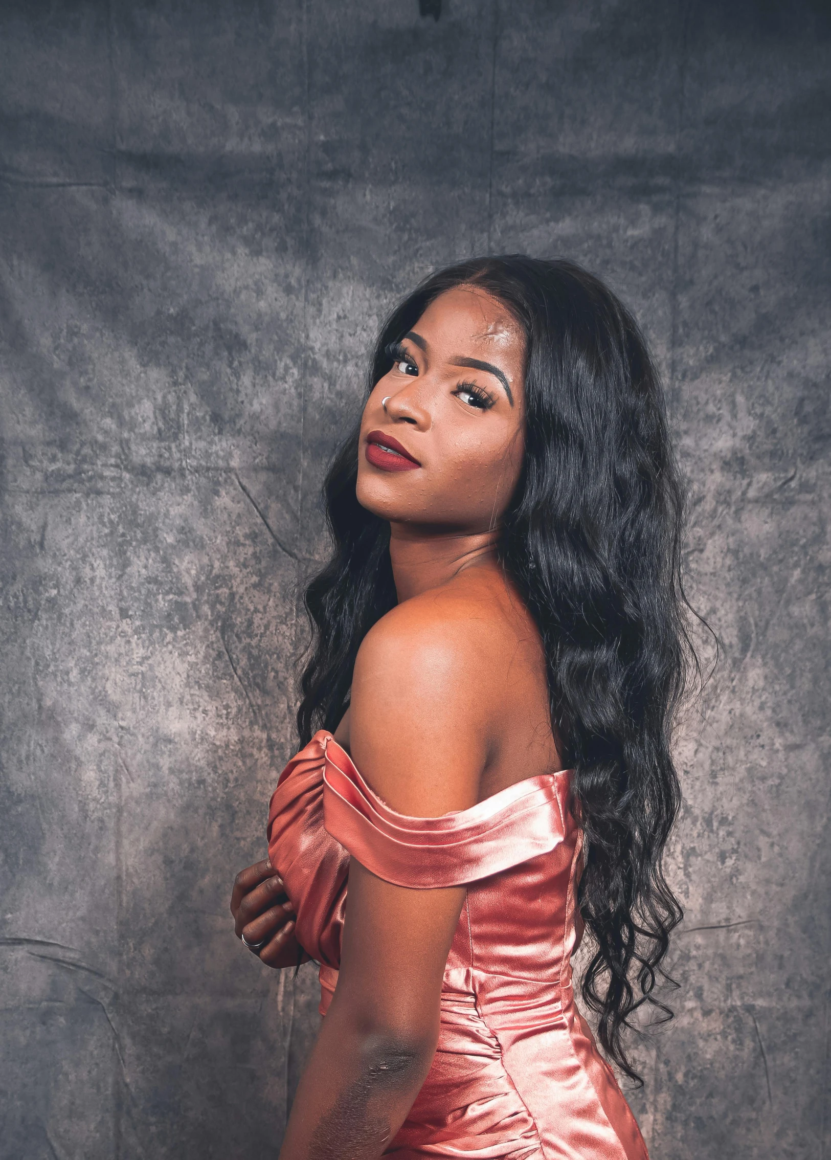 a woman with long hair and a red dress is posing for the camera