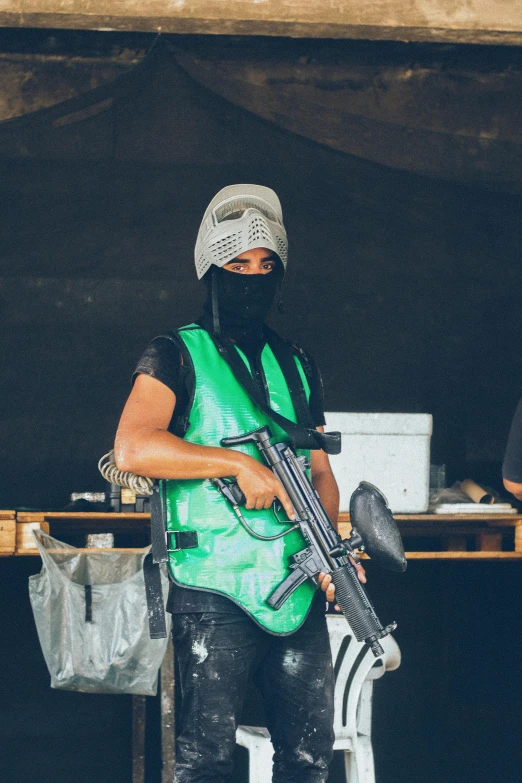 a man in green is holding an automatic rifle