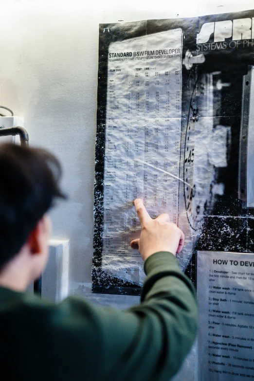 a person pointing at a poster on a wall