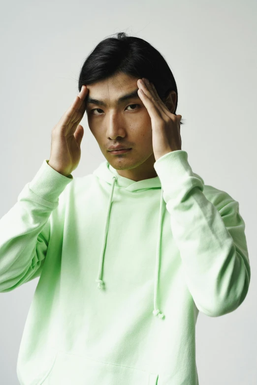 young man wearing green hoodie posing for a picture