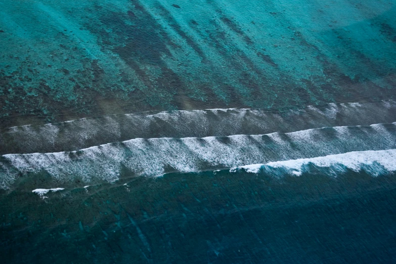 an aerial view of blue water near the shore