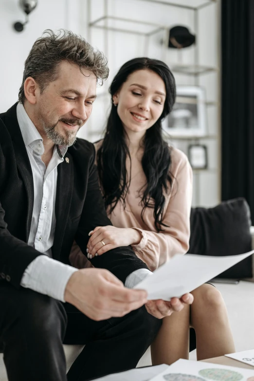 the man and woman are having fun with paper