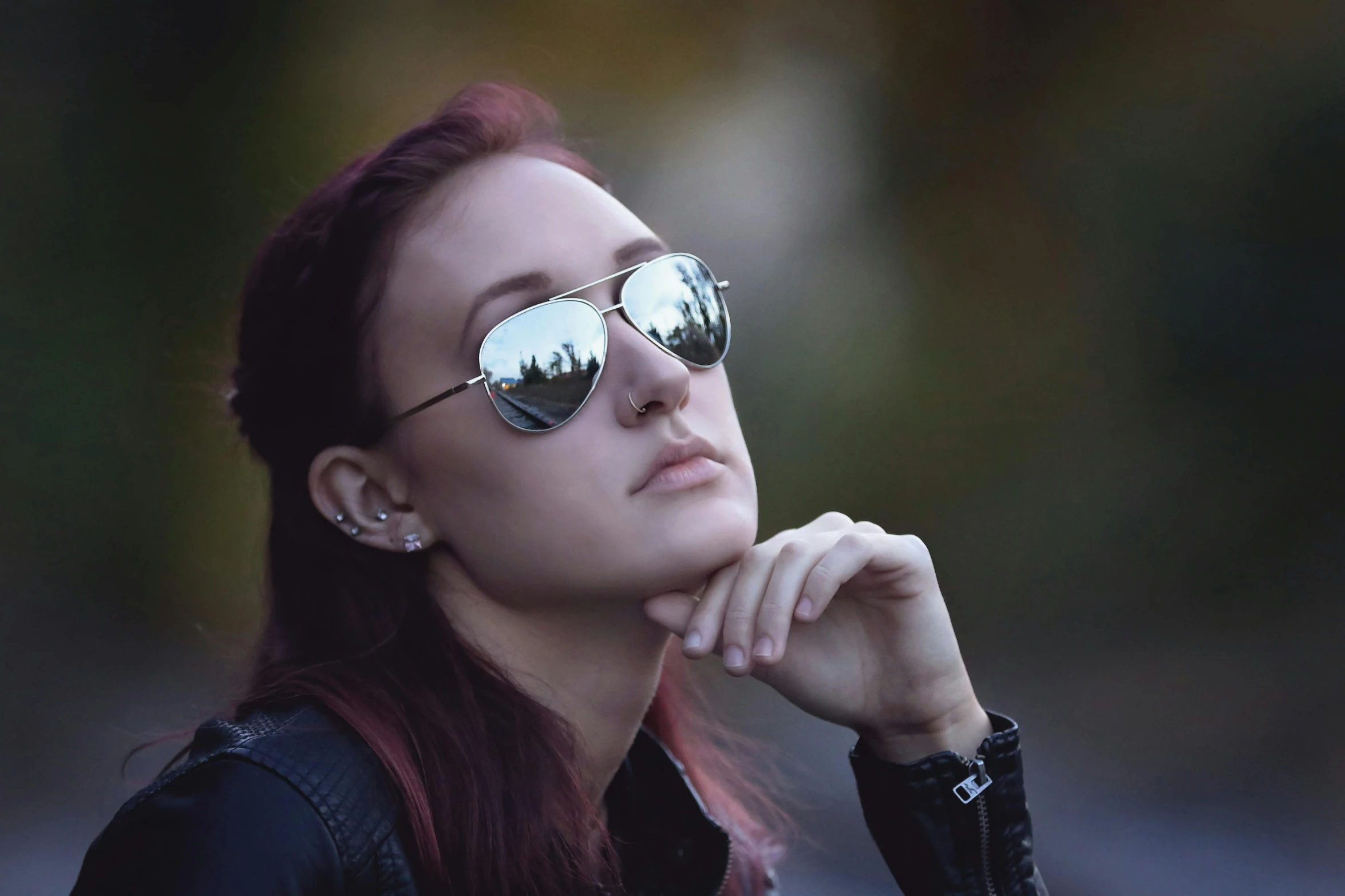 a woman wearing sunglasses looking away in an outdoor po