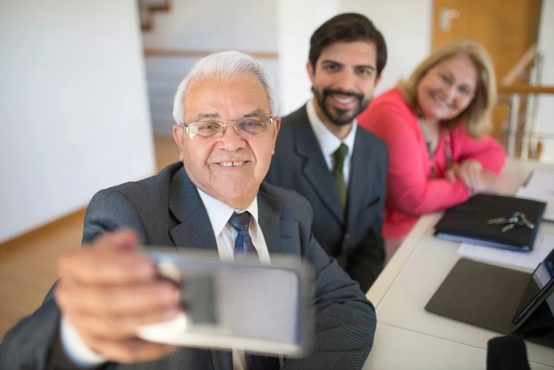 the man and woman are taking pictures with a cell phone