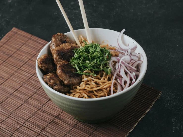 a bowl filled with rice, noodles, meat and vegetables